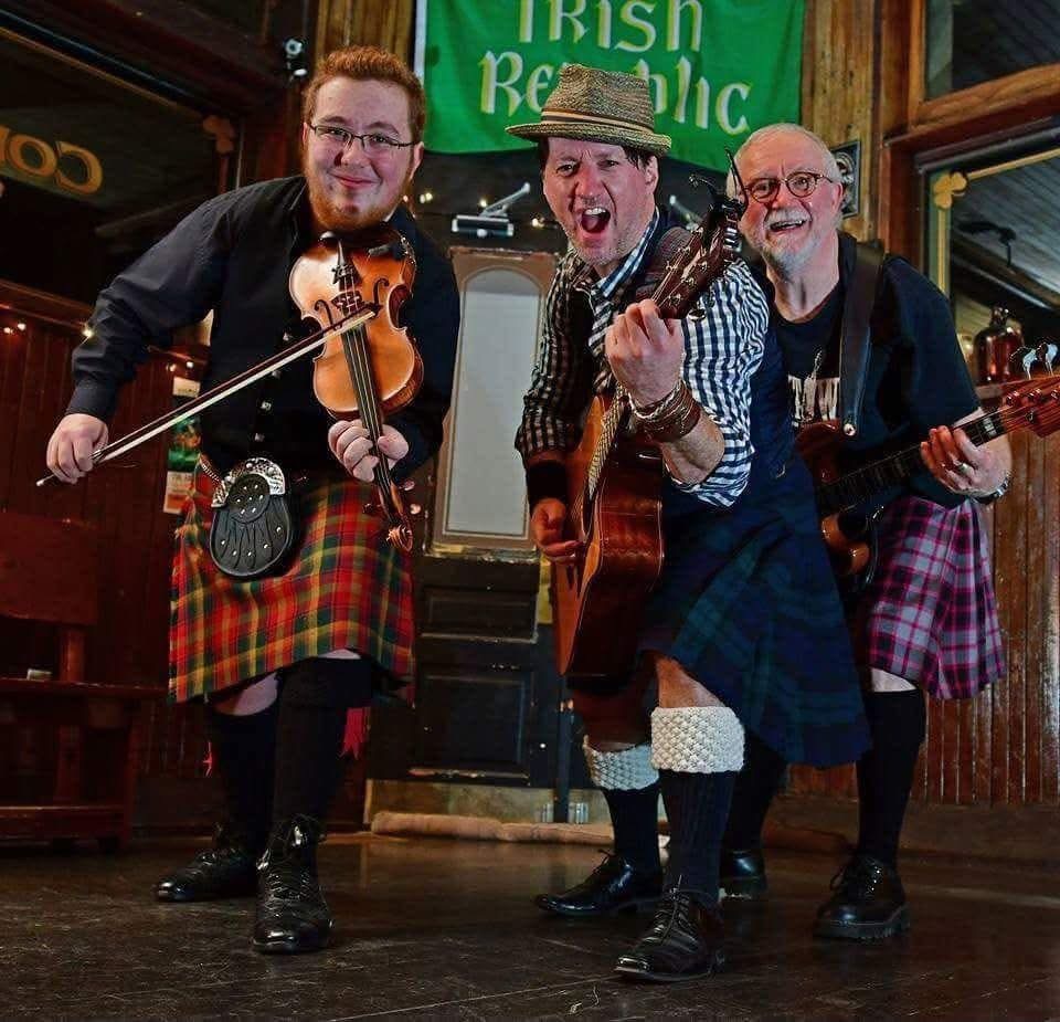 An archival photo of Liam, James and Owen playing together in kilts at the pub