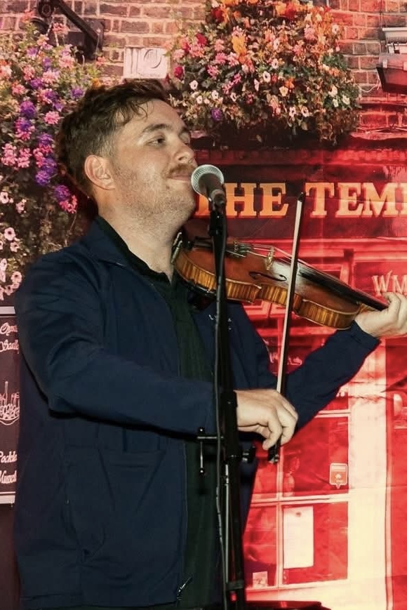 Liam playing fiddle at a pub